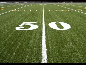 Still frame from an animation showing a football field at the 50-yard line on green turf